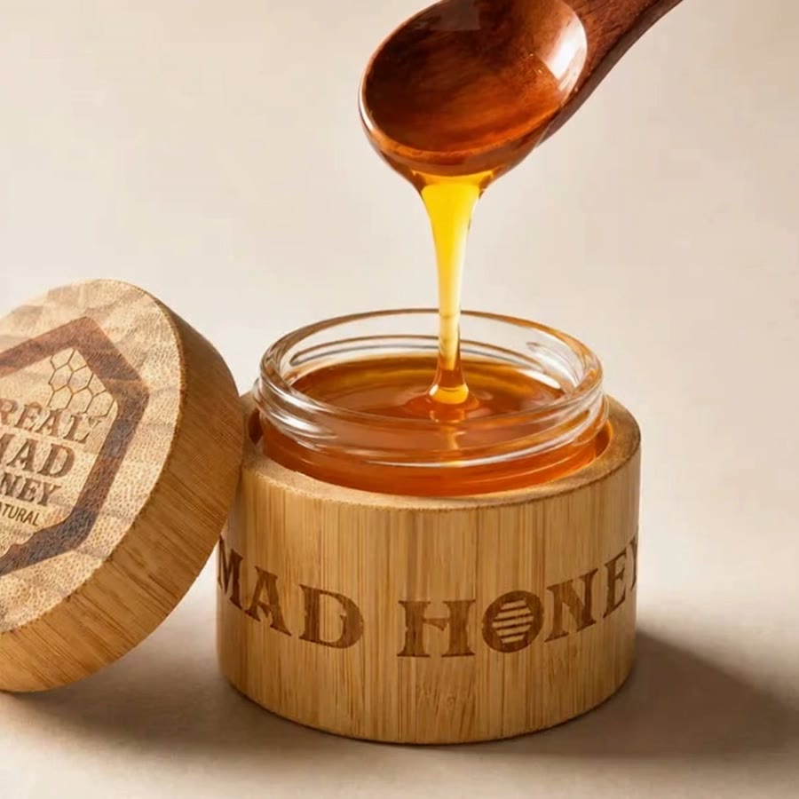Miele che cola da un cucchiaio di legno in un vasetto di bambù aperto di Real Mad Honey
